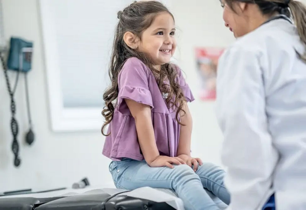 A pediatrician talks to a child in Tucson, AZ