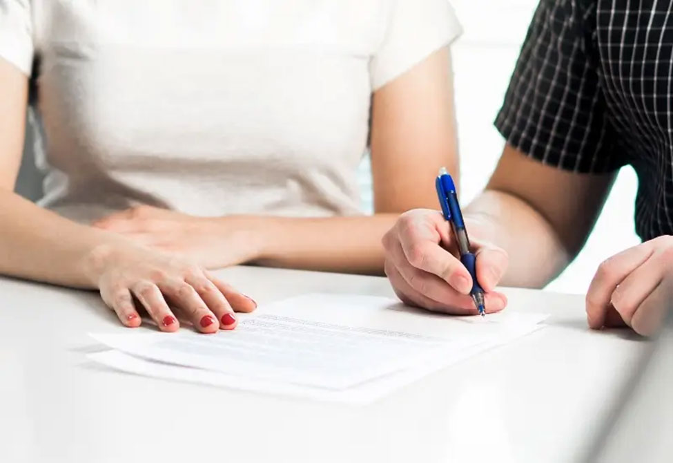 A couple signs divorce papers at a family lawyer’s office in Tucson, AZ